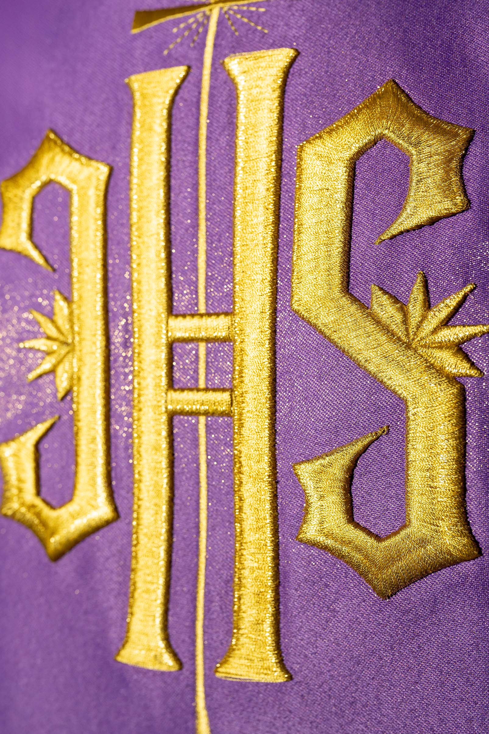 Pianeta viola riccamente decorata con motivo dorato e ampia fascia IHS