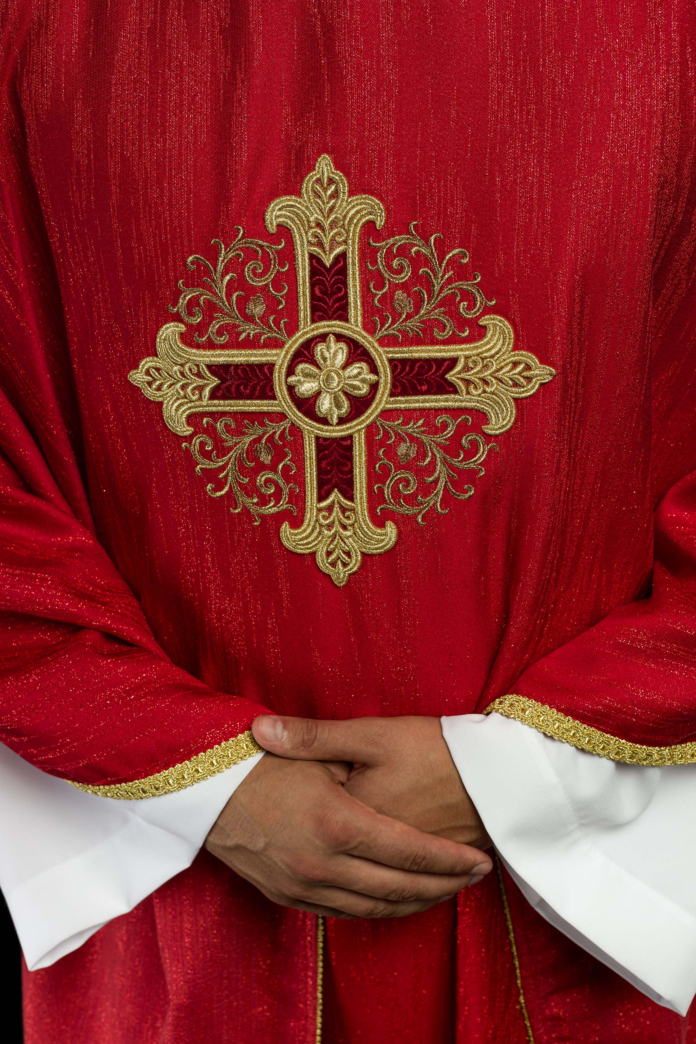 Casula rossa con motivo ricamato della croce su tessuto decorativo
