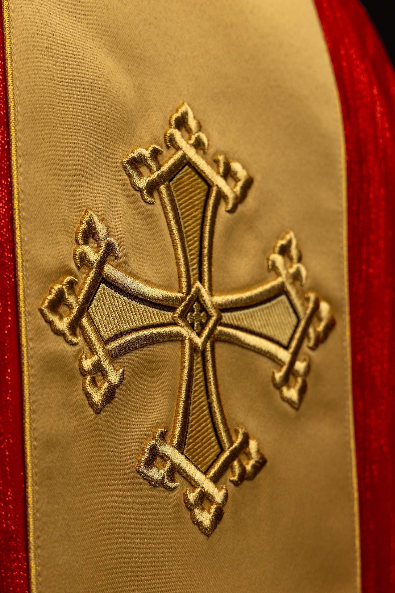 Casula rossa con motivo di croce ricamato e fascia in tessuto decorativo