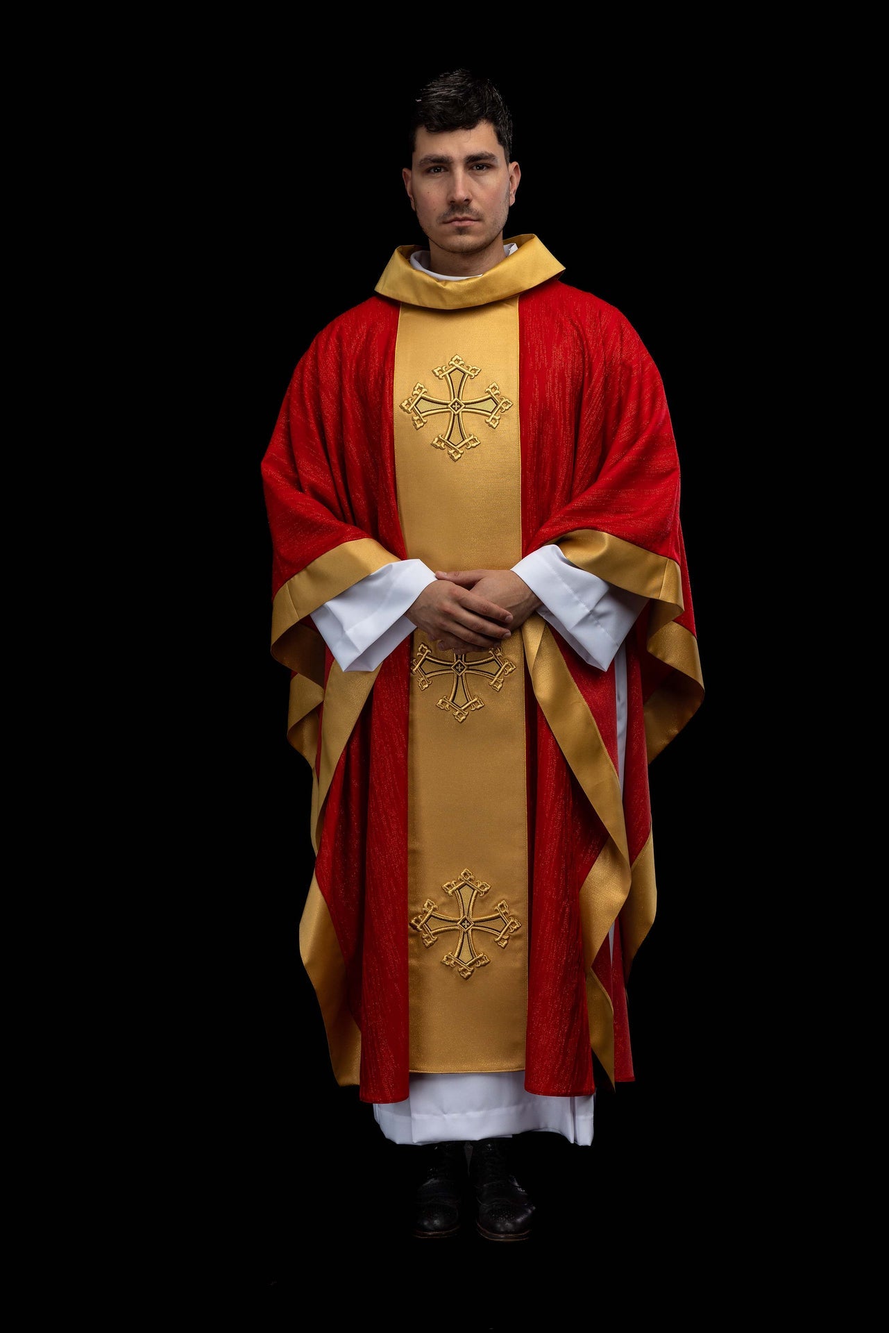 Czerwony ornat z haftowanym motywem krzyża z pasem na ozdobnej tkaninie