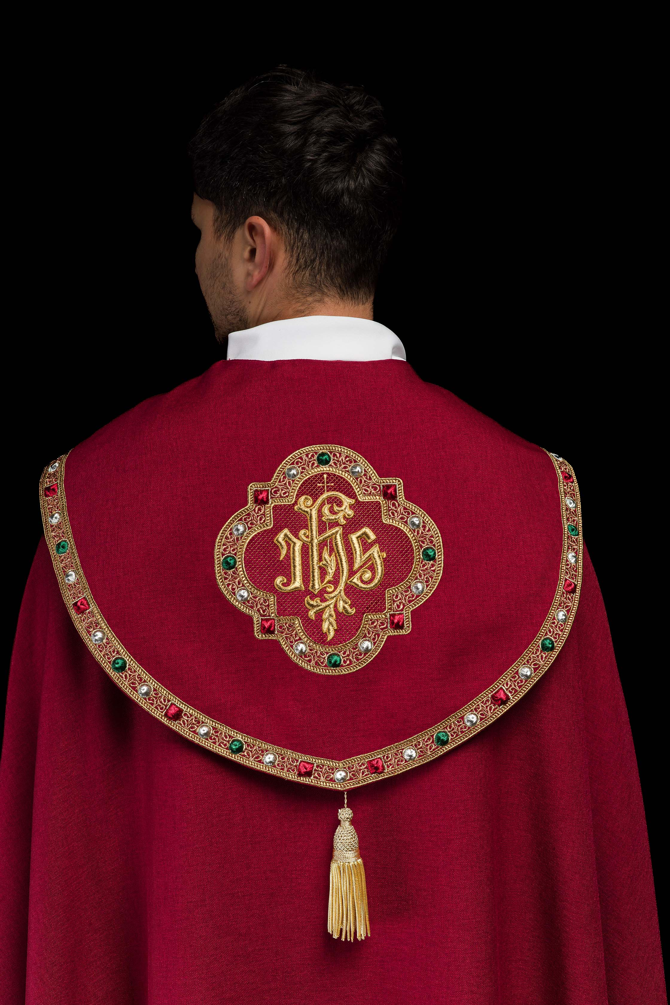Piviale liturgica rossa con il monogramma dorato IHS.