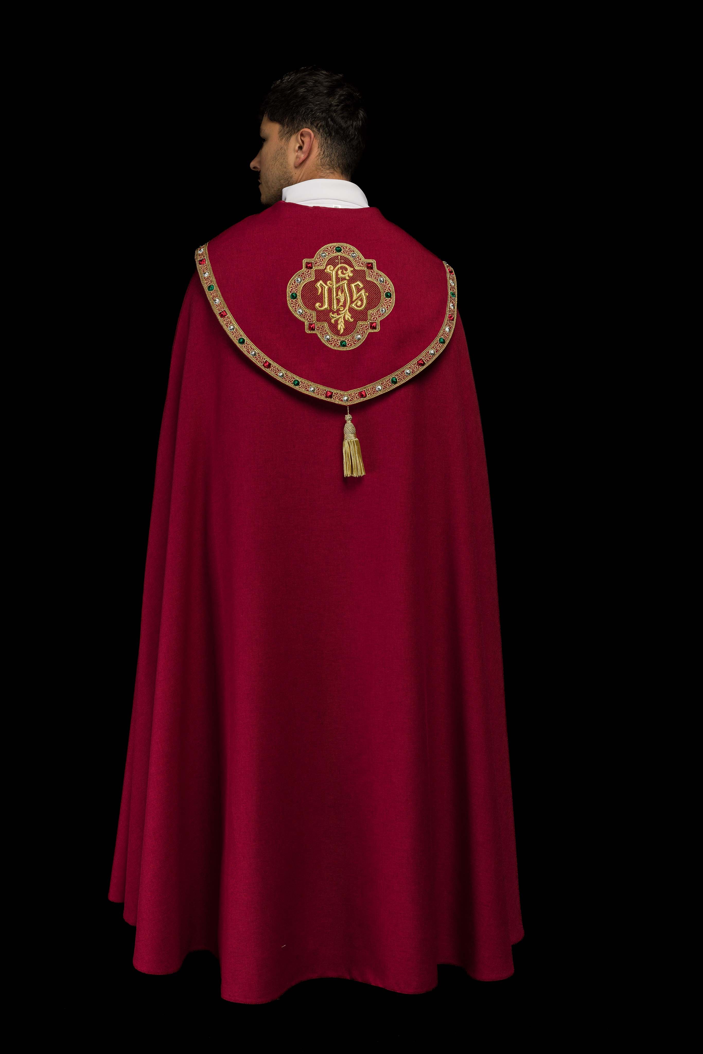 Una pianeta liturgica rossa con il monogramma dorato IHS.
