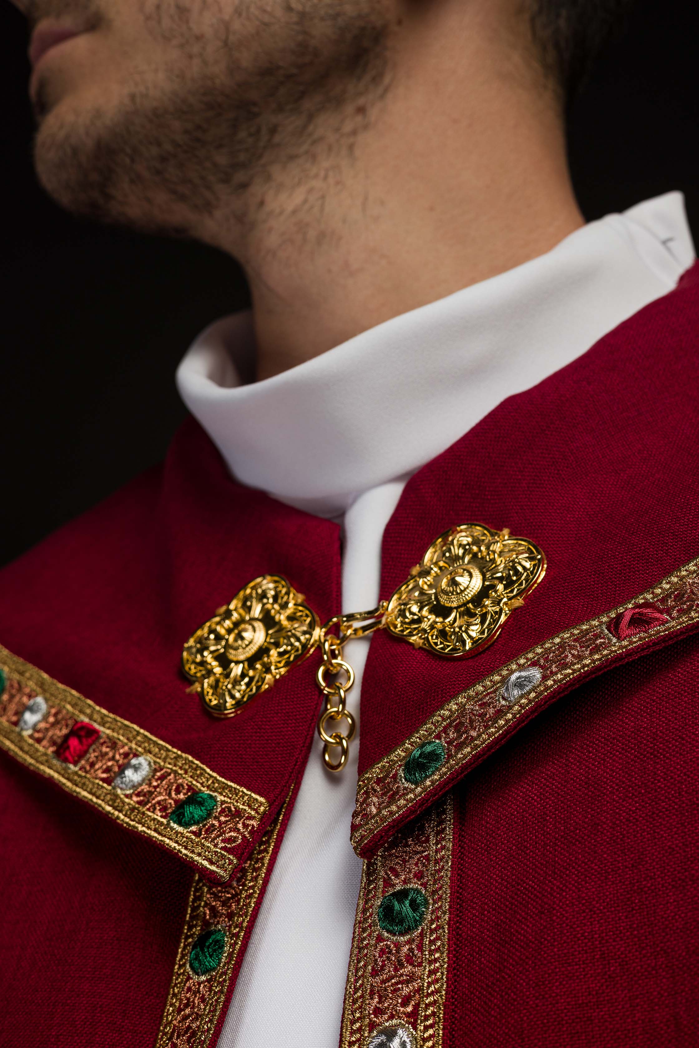 Una pianeta liturgica rossa con il monogramma dorato IHS.