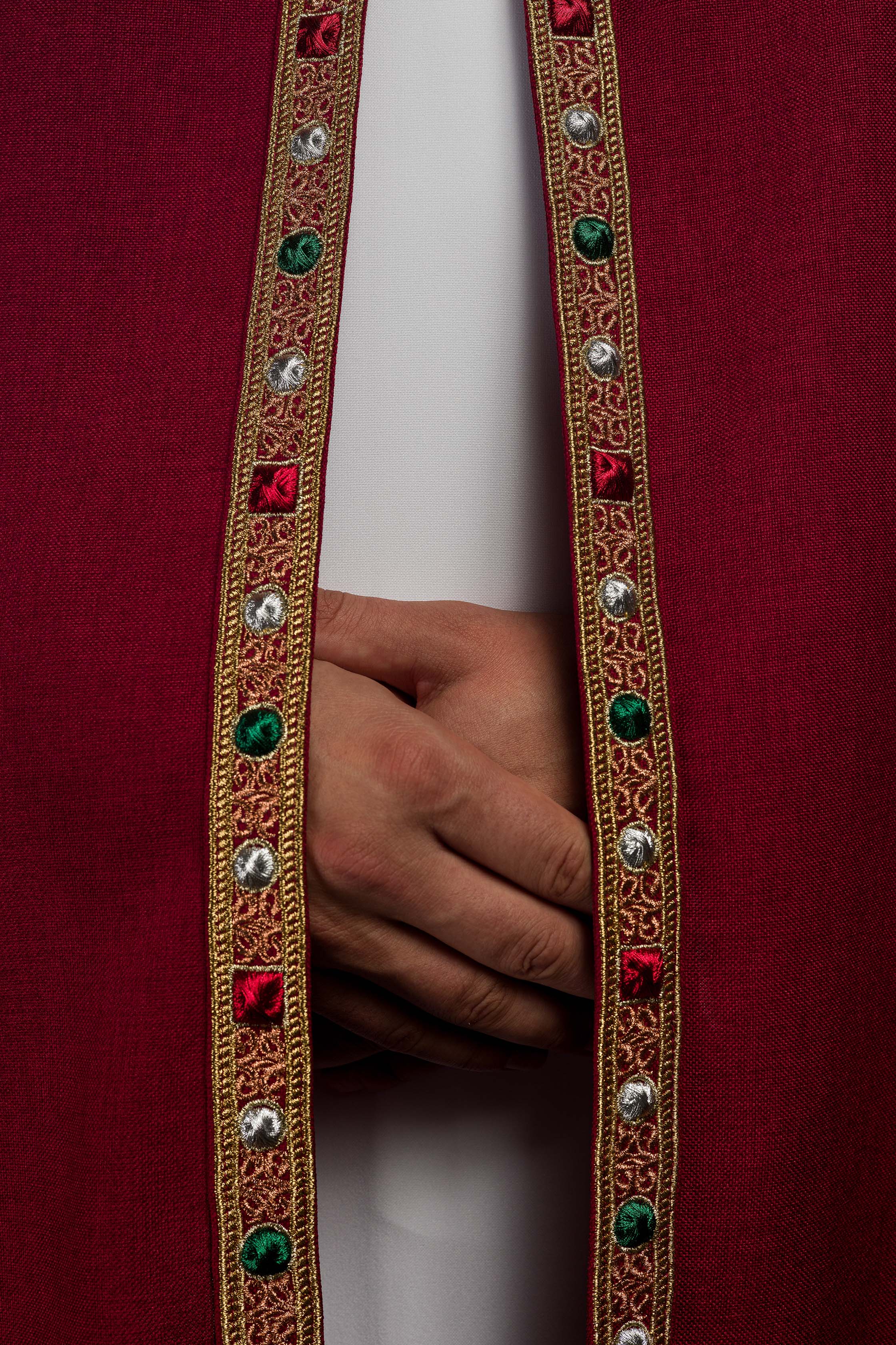 Una pianeta liturgica rossa con il monogramma dorato IHS.