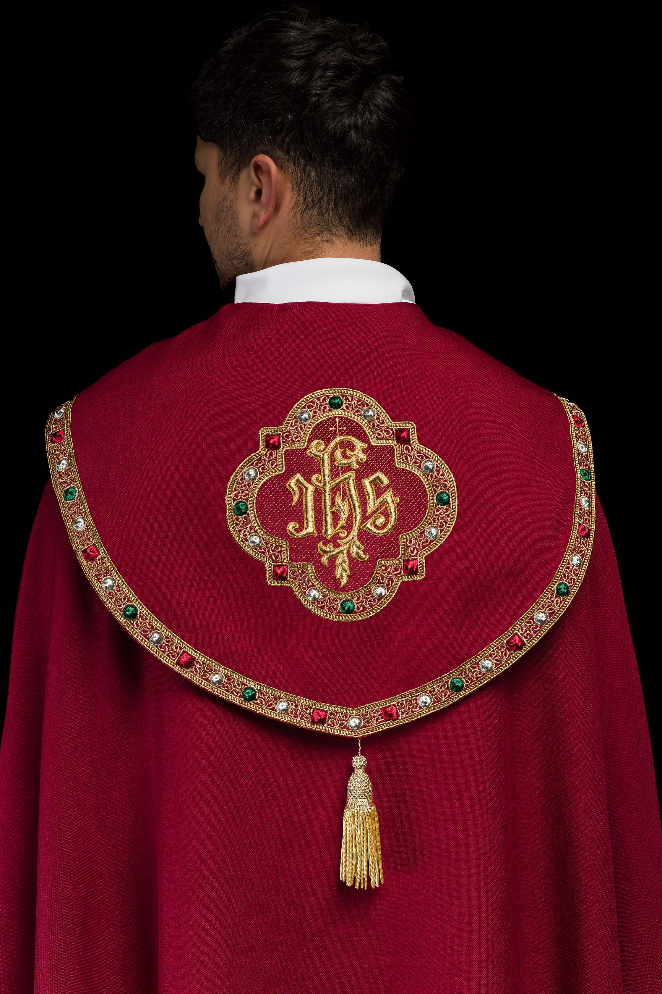 Una pianeta liturgica rossa con il monogramma dorato IHS.