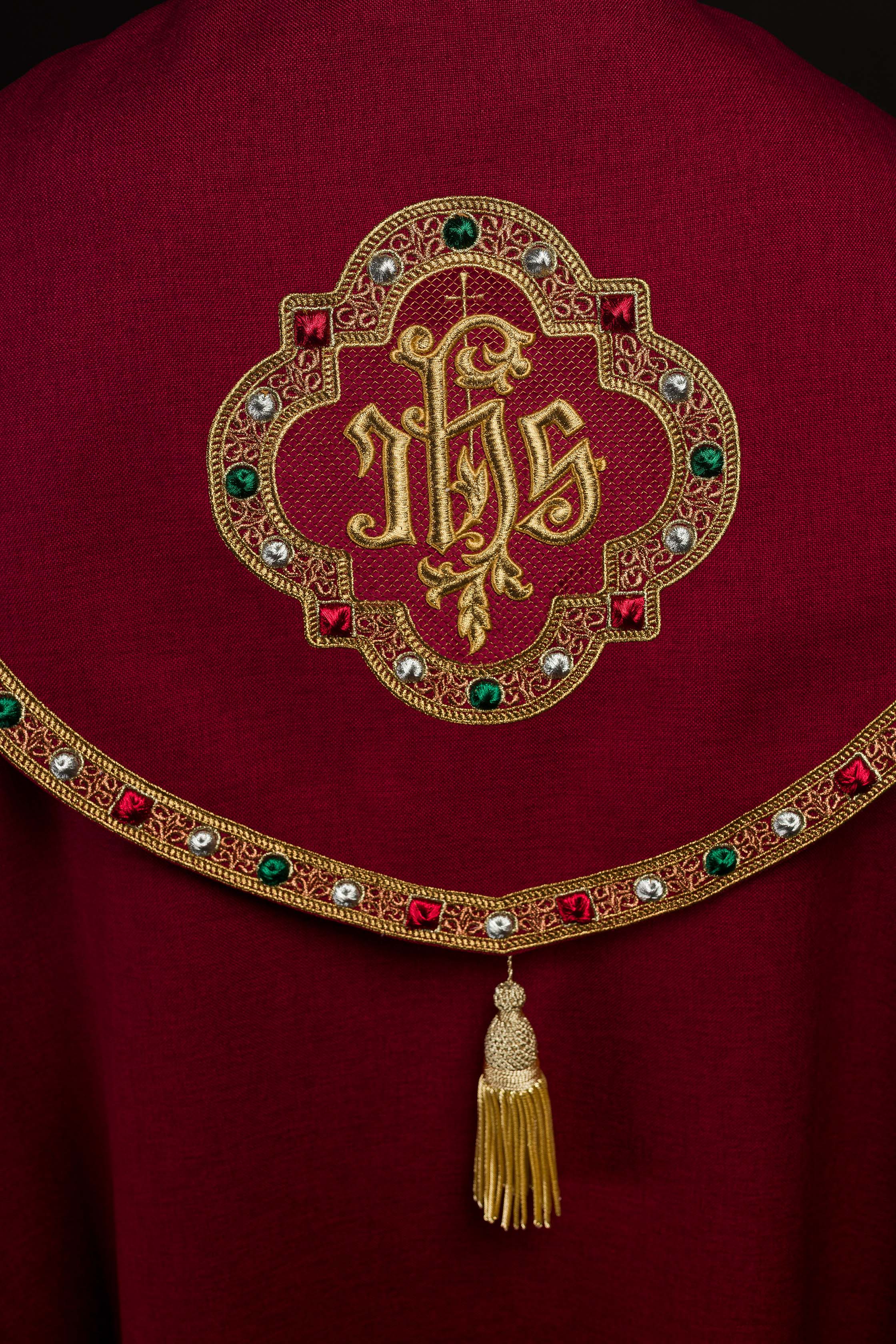 Una pianeta liturgica rossa con il monogramma dorato IHS.