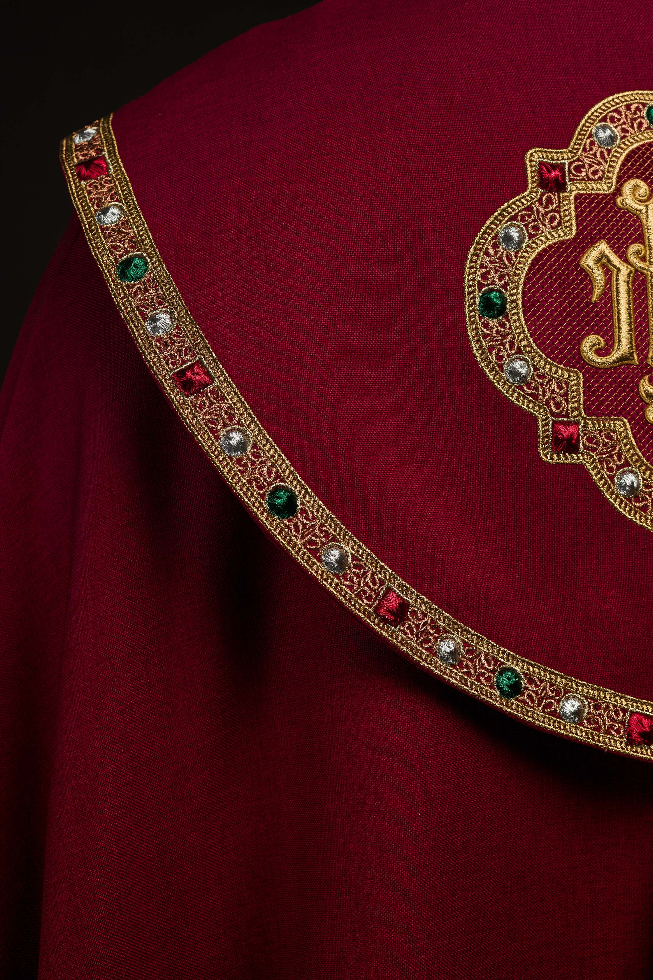 Una pianeta liturgica rossa con il monogramma dorato IHS.