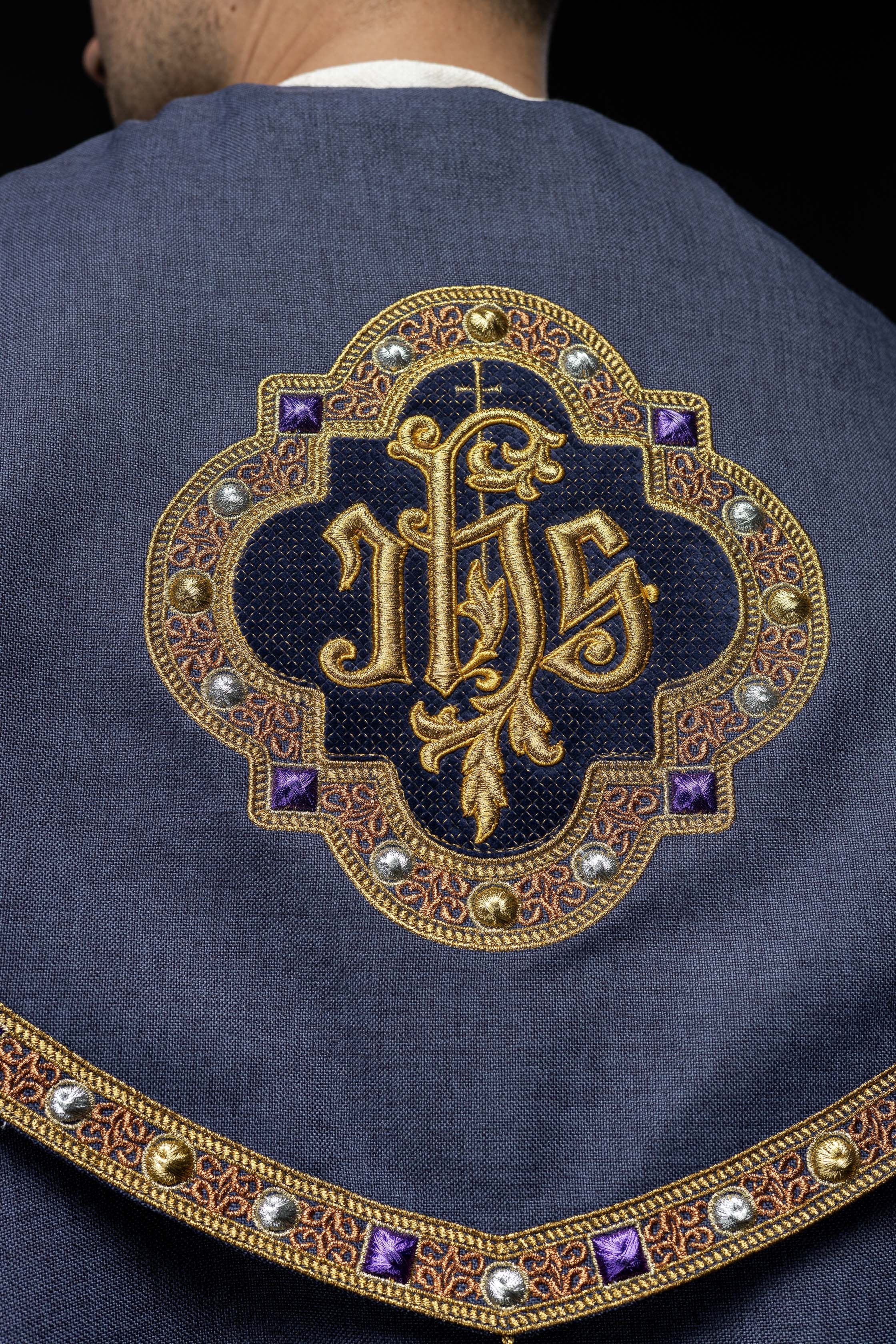 Una pianeta liturgica viola con il monogramma dorato IHS