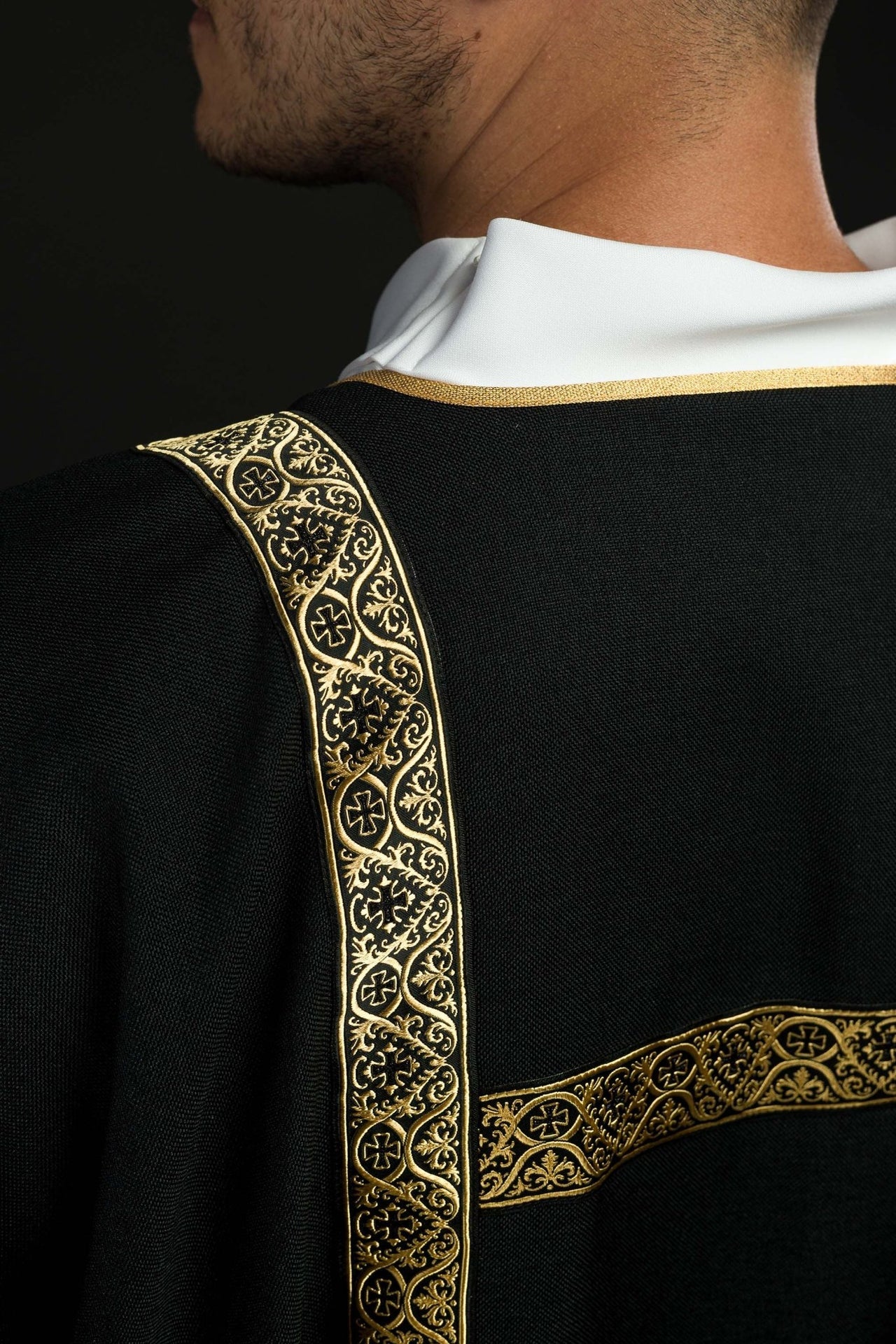 Dalmatyka czarna ozdobiona złotymi tasiemkami żakardowymi