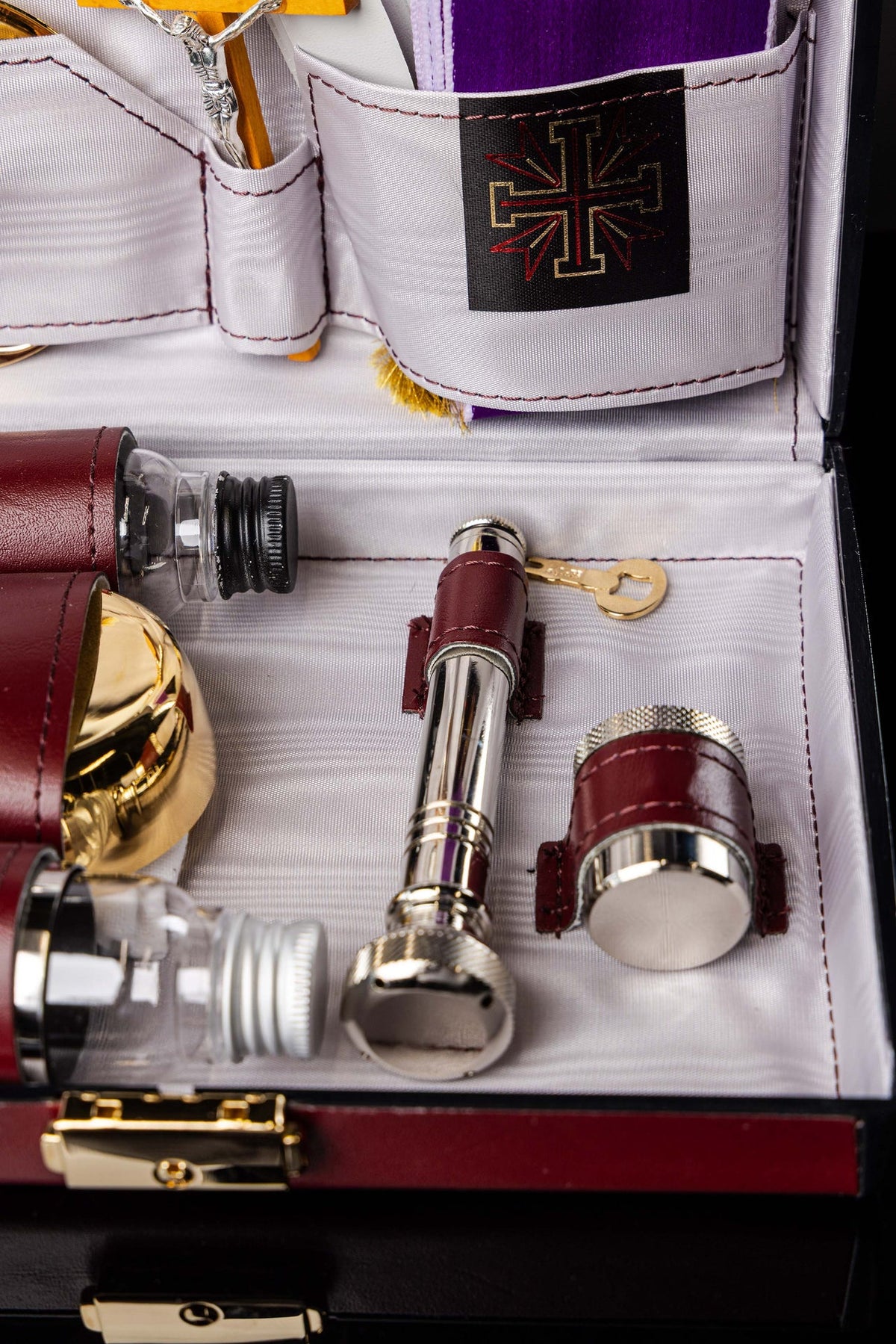 Dettaglio della valigetta liturgica con ampolle, pisside e accessori metallici