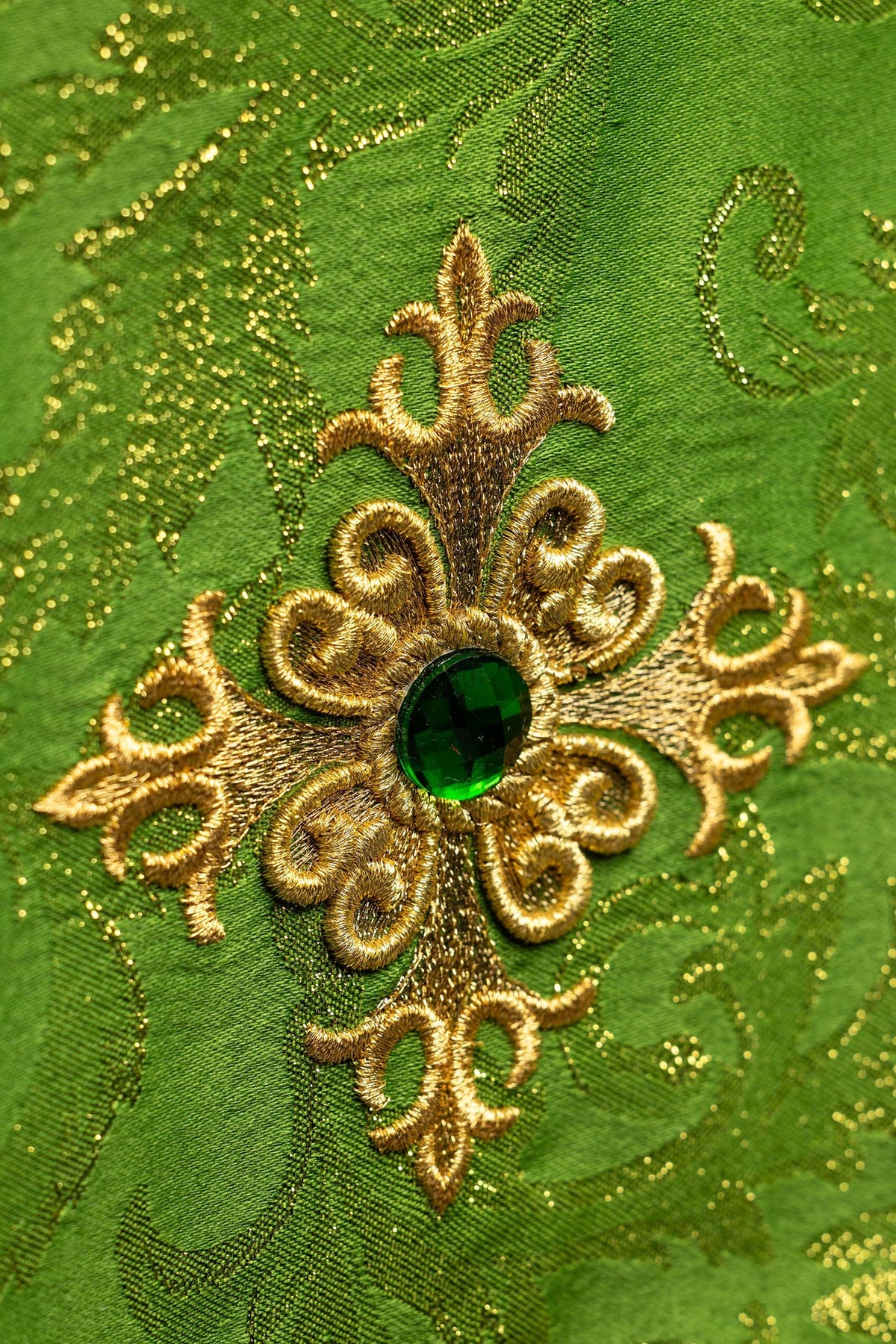 Copricalice ricamato, primo piano della croce dorata con pietra verde