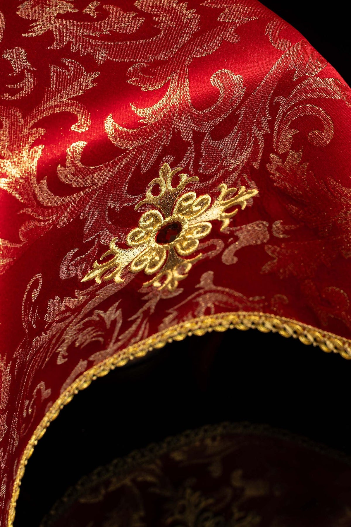 Copricalice rosso ricamato, dettaglio del tessuto damascato e del bordo dorato